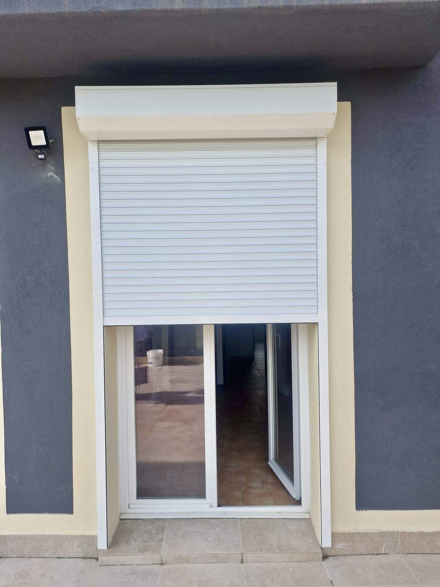 Porte-fenêtre coulissante avec volet roulant blanc et encadrement beige